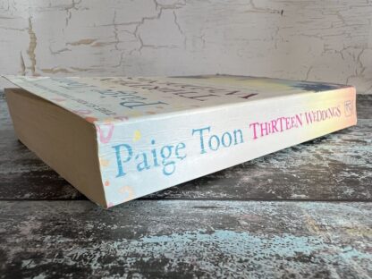 An image of a book by Paige Toon - Thirteen Weddings
