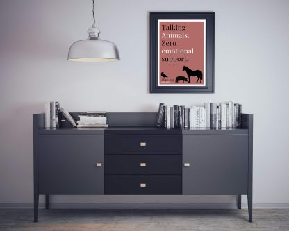 Humorous Animal Farm print in black frame on wall, with black sideboard and books below. From Bookish Prints collection by StrangeBooks UK