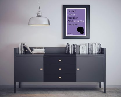 Humorous Hamlet print in black frame on wall, with black sideboard and books below. From Bookish Prints collection by StrangeBooks UK