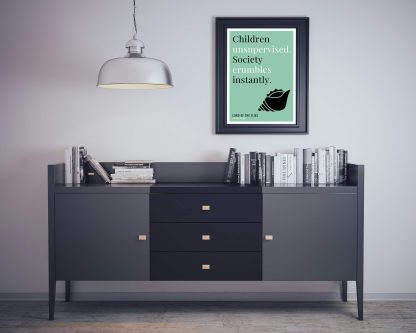 Humorous Lord of the Flies print in black frame on wall, with black sideboard and books below. From Bookish Prints collection by StrangeBooks UK