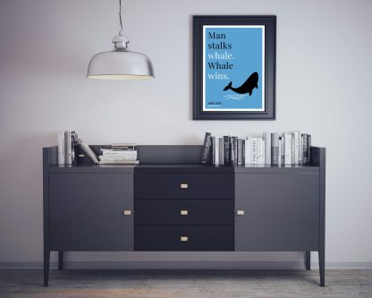 Humorous Moby Dick print in black frame on wall, with black sideboard and books below, Bookish Prints by StrangeBooks UK