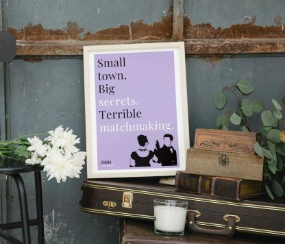 Humorous Emma print in white wooden frame, perched on a violin case next to some books. From Bookish Prints collection by StrangeBooks UK