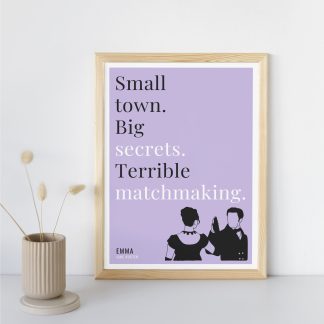 Humorous Emma print in wooden frame, leaning against a plain wall. Small beige decoration nearby. From Bookish Prints collection by StrangeBooks UK
