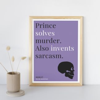 Humorous Hamlet print in wooden frame, leaning against a plain wall. Small beige decoration nearby. From Bookish Prints collection by StrangeBooks UK