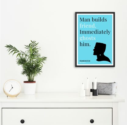 Humorous Frankenstein print in black frame on wall, with white chest of drawers and plants and candles below. From Bookish Prints collection by StrangeBooks UK