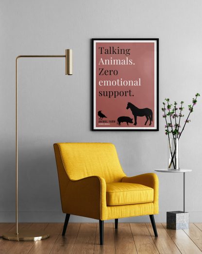 Humorous Animal Farm print in black frame on wall, with a yellow armchair in front next to a tall angular lamp and plant on a table. From Bookish Prints collection by StrangeBooks UK