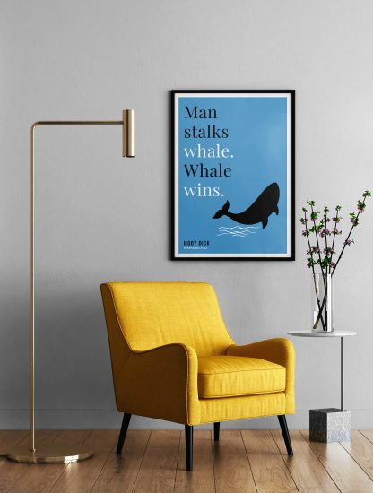 Humorous Moby Dick print in black frame on wall, with a yellow armchair in front next to a tall angular lamp and plant on a table. From Bookish Prints collection by StrangeBooks UK