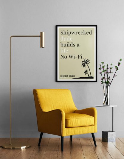 Humorous Robinson Crusoe print in black frame on wall, with a yellow armchair in front next to a tall angular lamp and plant on a table. From Bookish Prints collection by StrangeBooks UK