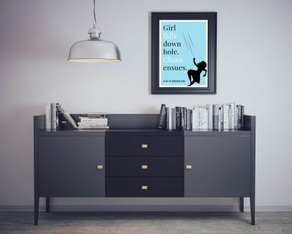 Humorous Alice in Wonderland print in black frame on wall, with black sideboard and books below. From Bookish Prints collection by StrangeBooks UK