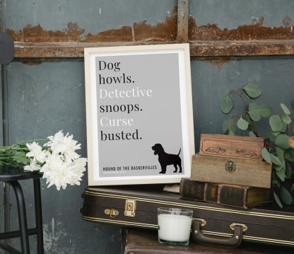 Humorous The Hound of the Baskervilles print in white wooden frame, perched on a violin case next to some books. From Bookish Prints collection by StrangeBooks UK
