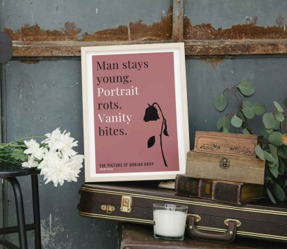 Humorous Picture of Dorian Gray print in white wooden frame, perched on a violin case next to some books. From Bookish Prints collection by StrangeBooks UK