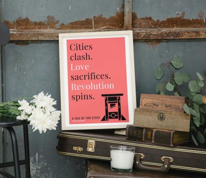 Humorous A Tale of Two Cities print in white wooden frame, perched on a violin case next to some books. From Bookish Prints collection by StrangeBooks UK