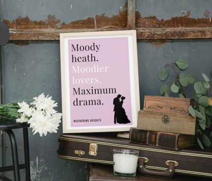 Humorous Wuthering Heights print in white wooden frame, perched on a violin case next to some books. From Bookish Prints collection by StrangeBooks UK