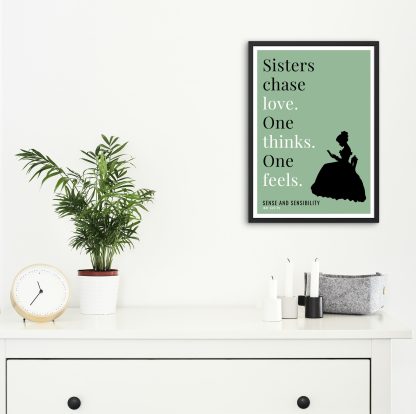 Humorous Sense and Sensibility print in black frame on wall, with white chest of drawers and plants and candles below. From Bookish Prints collection by StrangeBooks UK