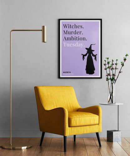 Humorous Macbeth print in black frame on wall, with a yellow armchair in front next to a tall angular lamp and plant on a table. From Bookish Prints collection by StrangeBooks UK