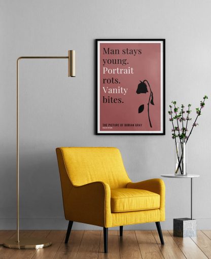 Humorous Picture of Dorian Gray print in black frame on wall, with a yellow armchair in front next to a tall angular lamp and plant on a table. From Bookish Prints collection by StrangeBooks UK
