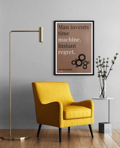 Humorous The Time Machine print in black frame on wall, with a yellow armchair in front next to a tall angular lamp and plant on a table. From Bookish Prints collection by StrangeBooks UK