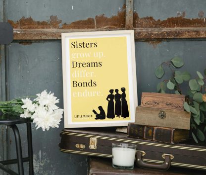 Humorous Little Women print in white wooden frame, perched on a violin case next to some books. From Bookish Prints collection by StrangeBooks UK